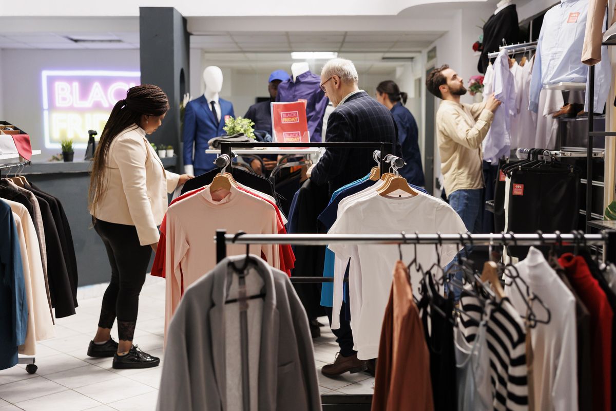 Loja de roupas com clientes escolhendo peças nas araras